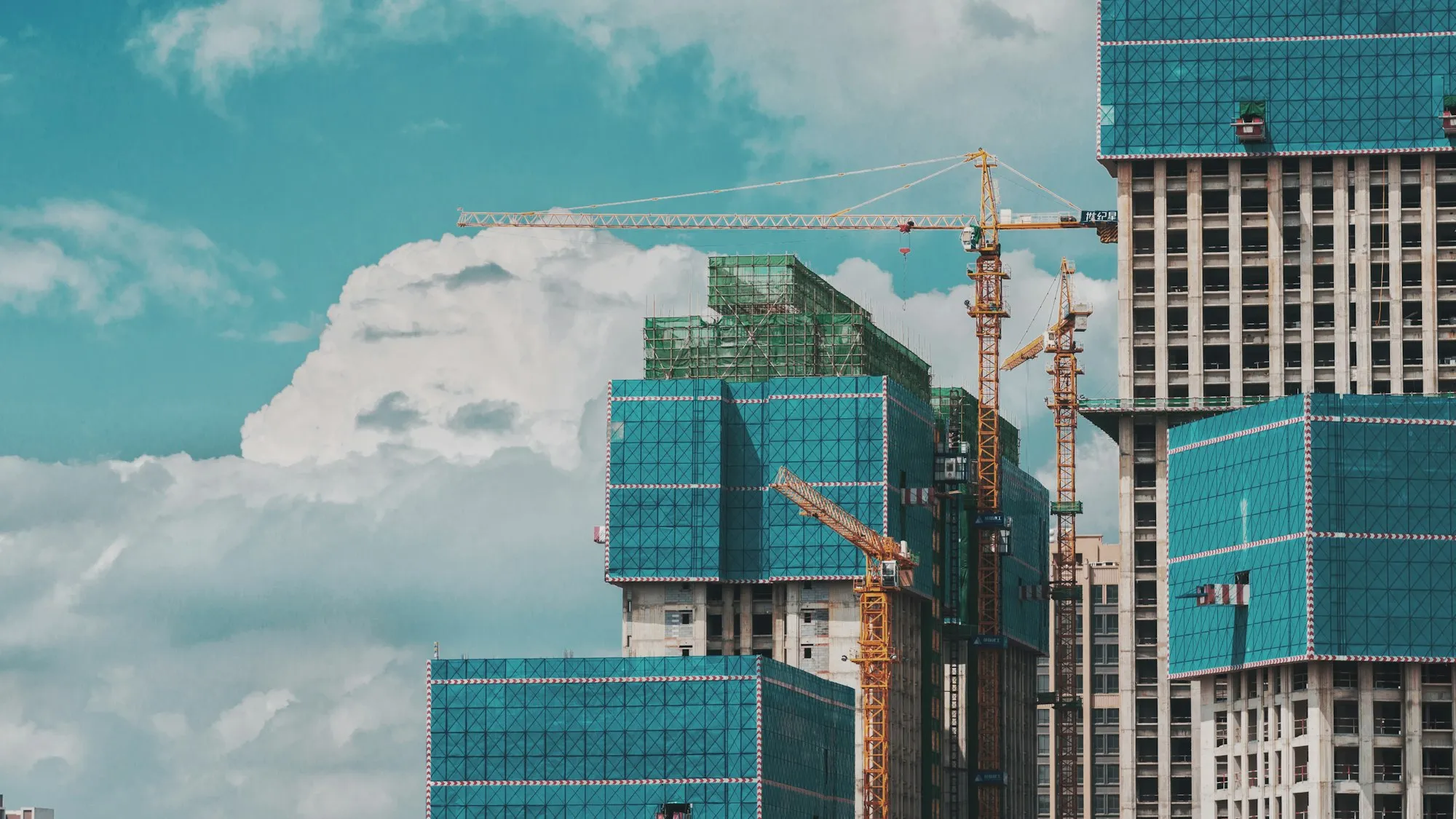 Stacked modular building units waiting to be lifted into a steel frame
